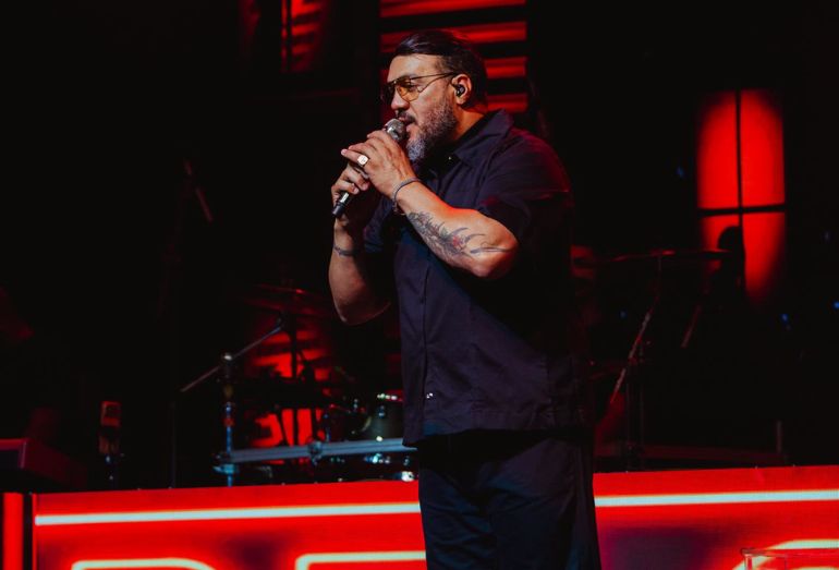 Belo exibe cena de beijo com Viviane Araújo em telão de show